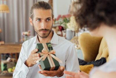 Photo by ANTONI SHKRABA: https://www.pexels.com/photo/bearded-man-holding-a-gift-box-5493189/