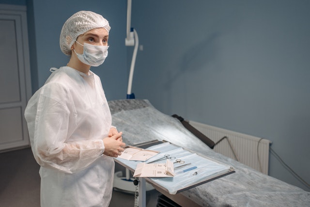 Photo by Pavel Danilyuk: https://www.pexels.com/photo/woman-in-white-protective-suit-waiting-inside-a-room-7108150/