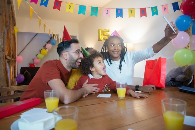 Photo by Kampus Production: https://www.pexels.com/photo/a-family-with-party-hats-taking-a-groupfie-7159843/