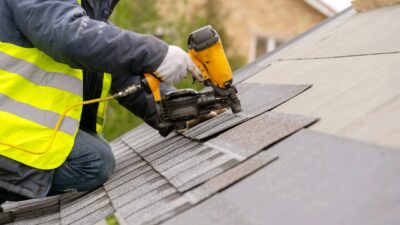 Image Attribution Adobe Stock royalty-free image #268599626, 'Workman using pneumatic nail gun install tile on roof of new house under construction' uploaded by brizmaker, standard license purchased from https://stock.adobe.com/images/download/268599626; file retrieved on July 18th, 2019. License details available at https://stock.adobe.com/license-terms - image is licensed under the Adobe Stock Standard License