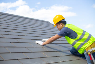 Adobe Stock royalty-free image #223738409, 'Builder Working On Roof Of New Building, Construction worker wearing safety harness and safety line working on roof new warehouse.'