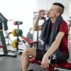Photo by ShotPot: https://www.pexels.com/photo/man-in-black-and-red-crew-neck-t-shirt-sitting-on-black-and-red-exercise-equipment-4047244/