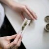 Unsplash.com royalty-free image #UoXLndT32Hg, 'person making cannabis joint' uploaded by Thought Catalog (https://unsplash.com/@thoughtcatalog), retrieved from https://unsplash.com/photos/UoXLndT32Hg on October 12th, 2018. License details available at https://unsplash.com/license - image is licensed under the Unsplash License