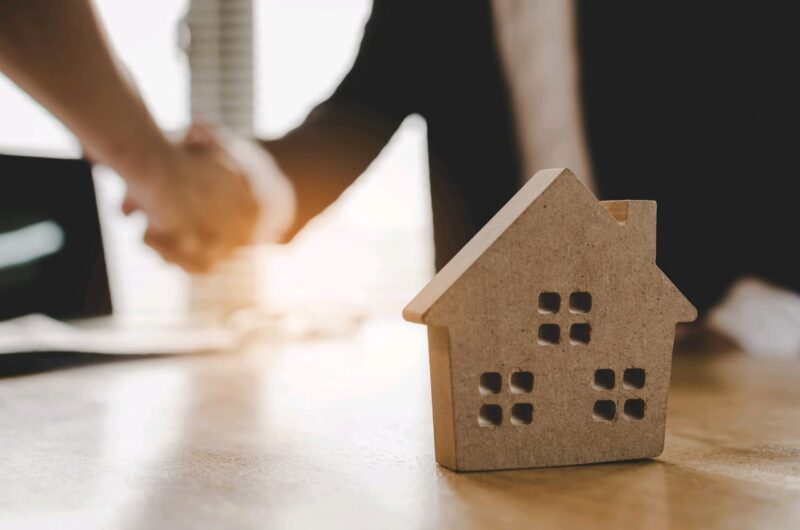Adobe Stock royalty-free image #241752991, 'real estate broker manager hand shake to customer after signing contract for buying house in estate agent office behind House model, investment, home loan contract, buy and sell house concept' uploaded by Vittaya_25, standard license purchased from https://stock.adobe.com/images/download/241752991; file retrieved on June 12th, 2019. License details available at https://stock.adobe.com/license-terms - image is licensed under the Adobe Stock Standard License