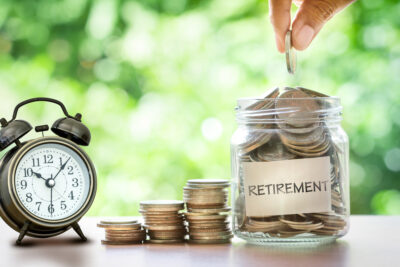 Adobe Stock royalty-free image #126525020, 'Hand putting Coins in glass jar with retro alarm clock , retirement' uploaded by Cozine, standard license purchased from https://stock.adobe.com/images/download/126525020; file retrieved on December 19th, 2018. License details available at https://stock.adobe.com/license-terms - image is licensed under the Adobe Stock Standard License