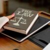 Photo by Mikhail Nilov: https://www.pexels.com/photo/a-person-holding-a-the-law-book-8731037/