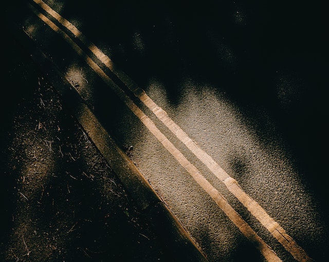 Photo by Harry Cooke: https://www.pexels.com/photo/asphalt-road-with-marking-lines-near-soil-and-shadows-6195088/