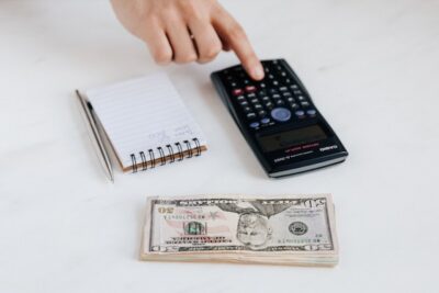 Photo by Karolina Grabowska: https://www.pexels.com/photo/crop-unrecognizable-accountant-using-calculator-near-pile-of-american-dollars-4386322/