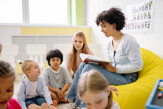 Photo by Yan Krukov: https://www.pexels.com/photo/woman-reading-a-book-to-the-children-8613089/