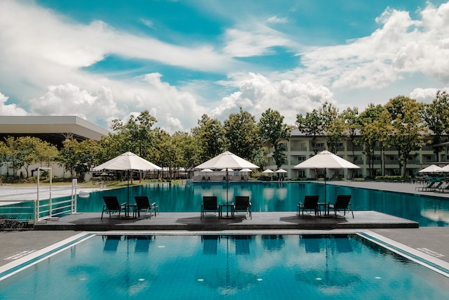 Photo by Donald Tong: https://www.pexels.com/photo/black-outdoor-lounge-chair-in-between-blue-swimming-pool-under-white-cloudy-blue-sky-189296/
