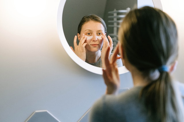 Photo by Ivan Samkov: https://www.pexels.com/photo/woman-putting-on-under-eye-patches-in-front-of-a-round-wall-mirror-4491173/